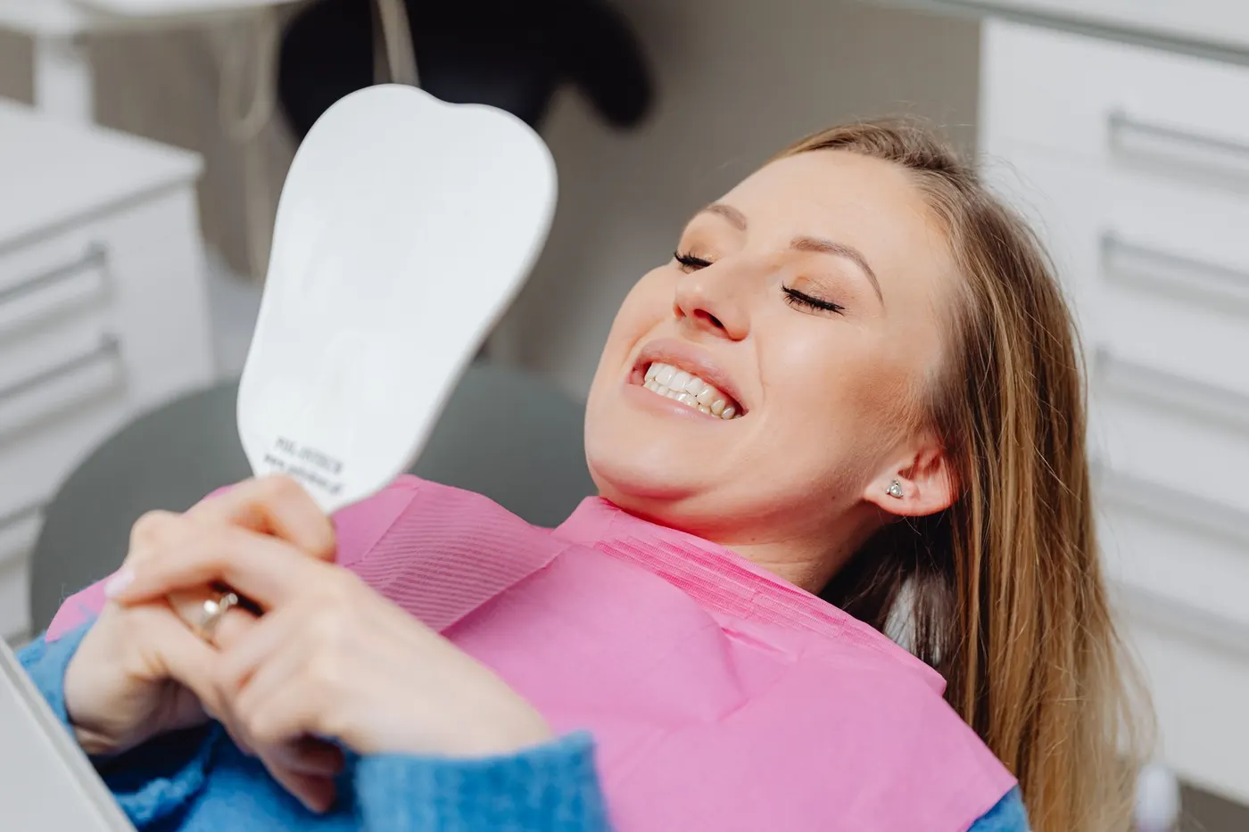 A patient looking at the result in a mirror after the treatment