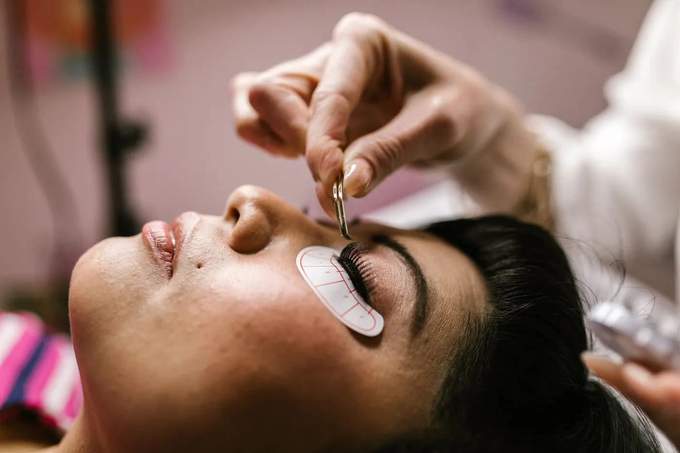 A lash lift in a salon — a silicone shield on the eyelid with lashes laid over it