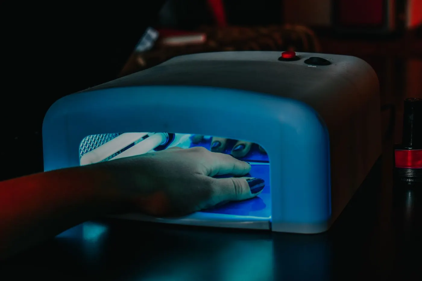 Gel polish curing under an LED lamp — each layer separately
